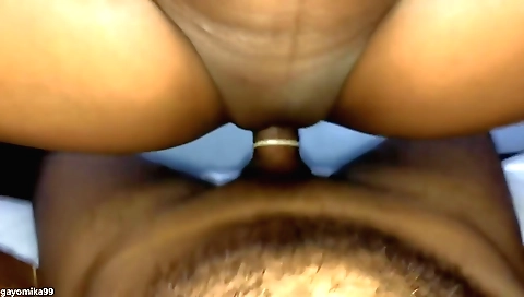 Indian brunette in red dress and black shorts in bedroom